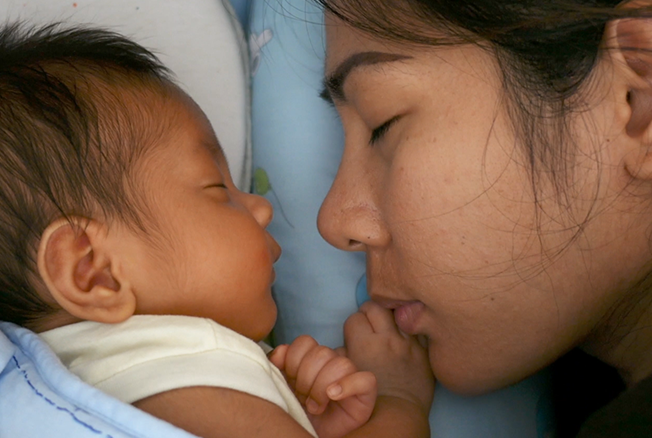 Mother tenderly bonding with her newborn baby
