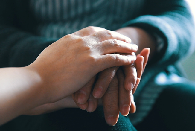 Hands clasped together in a gesture of comfort and support