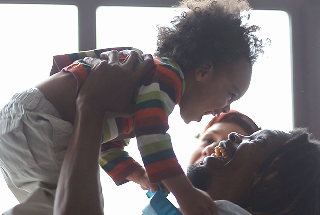 Parent joyfully lifting a young child into the air